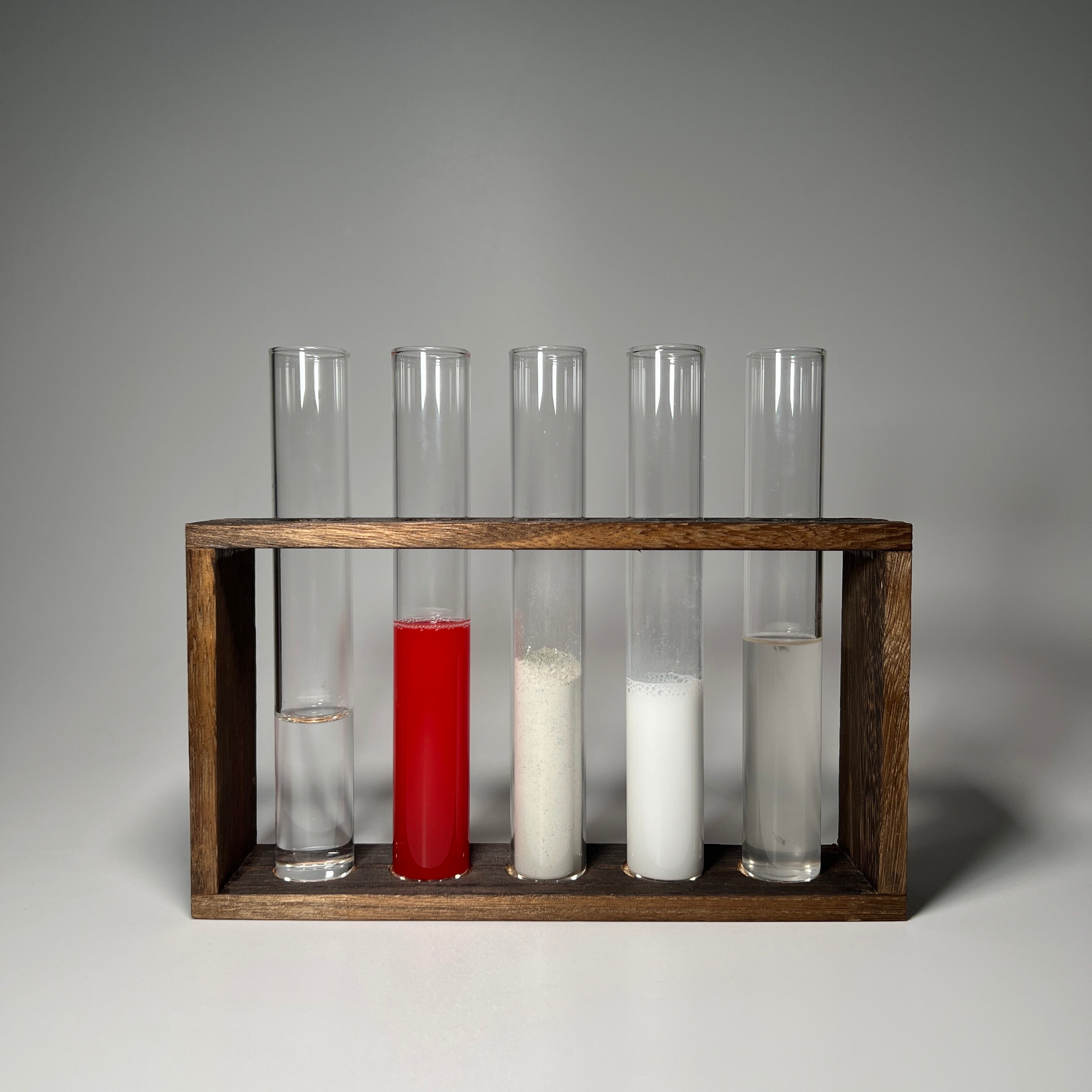 A selection of test tubes showcasing different materials used in the casting process for luxury house signs. Precision and craftsmanship come together to create elegant, long-lasting prismatic stone house numbers.