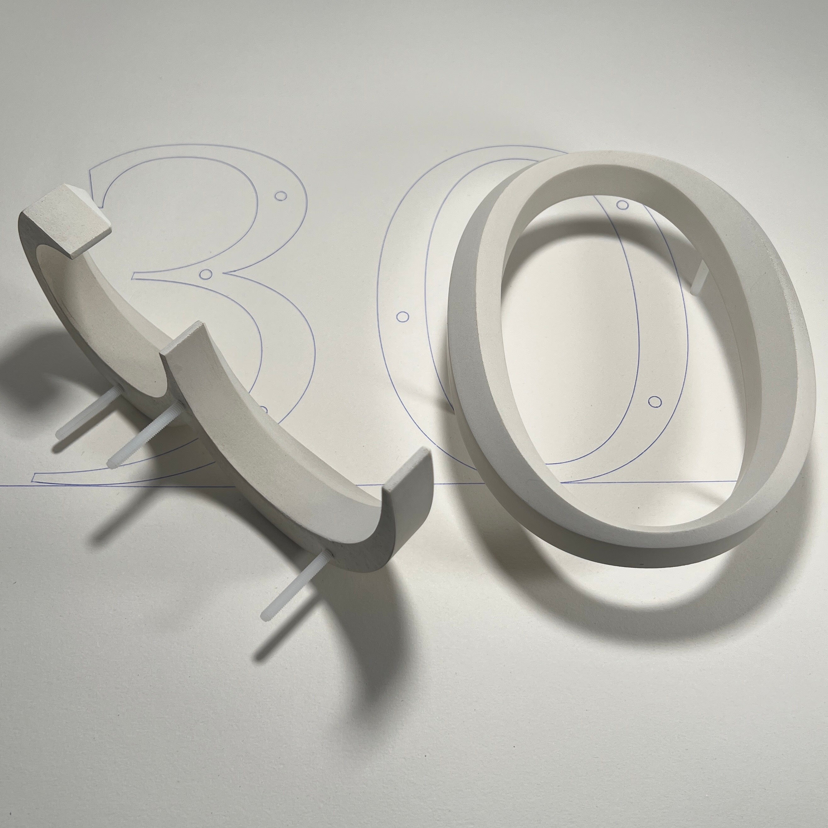 Cast stone house number sign '30' on a mounting template, featuring a floating prismatic design. This luxury house sign is crafted for modern and classical homes, offering timeless elegance with easy wall-mounting precision.