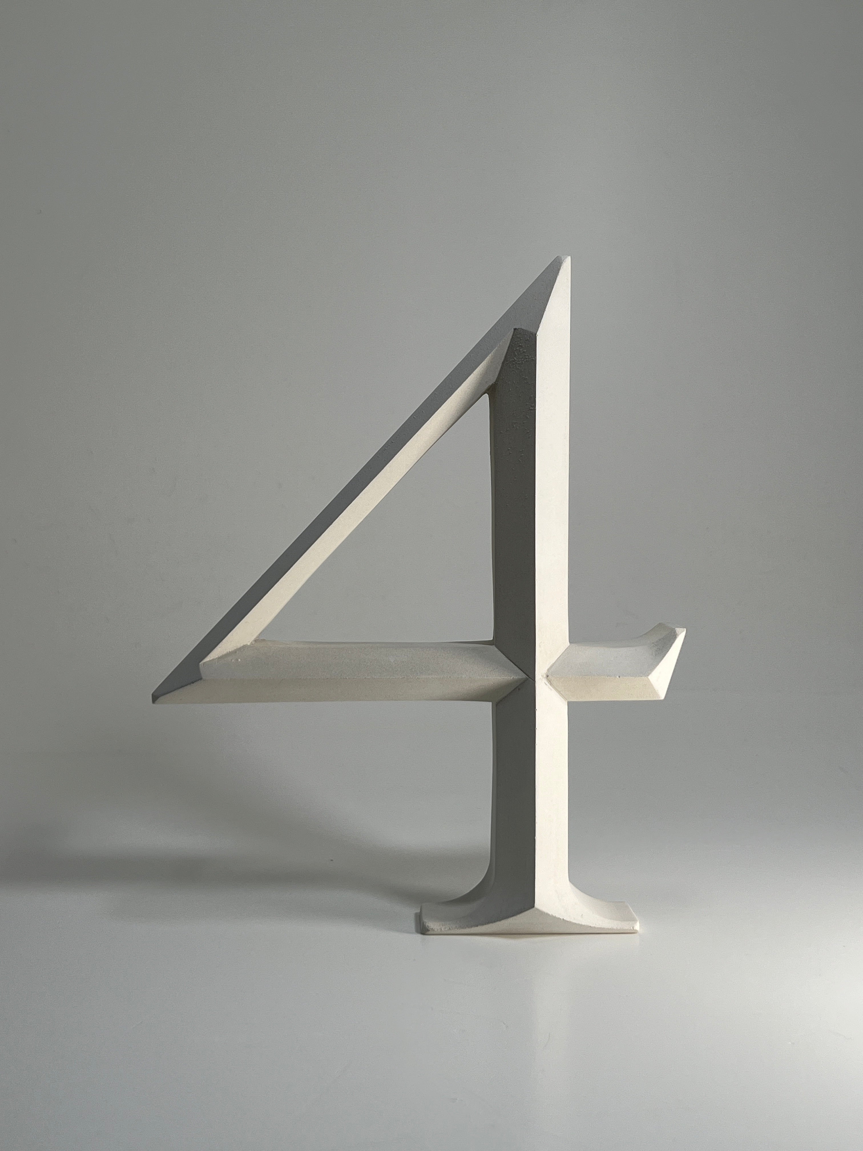 Cast stone house number '4' with a floating prismatic design, crafted for elegant homes and modern signs. A sleek and timeless architectural piece suitable for contemporary and classic homes.