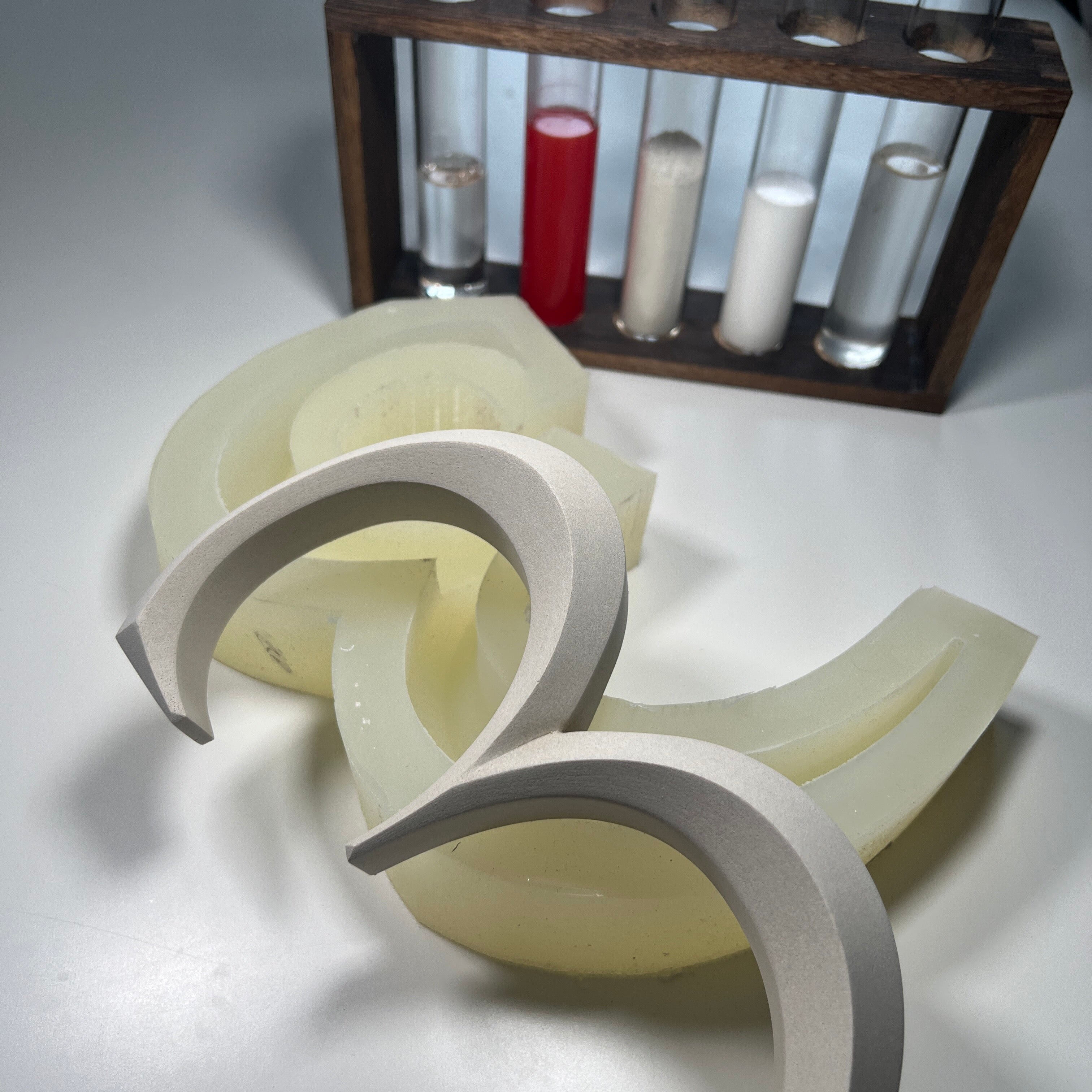 A behind-the-scenes look at the luxury cast stone house number production process, featuring a precision-cut  silicon mold and material samples. A testament to craftsmanship and high-quality architectural signage.